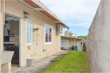 Beige single-story house with small lawn, cement walkway and AC Coronado Panama