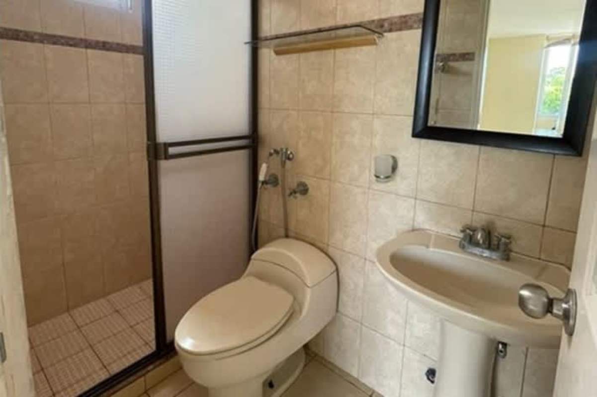 Tiled bathroom with shower enclosure, pedestal sink mirror PH Camino Real Betania Panama