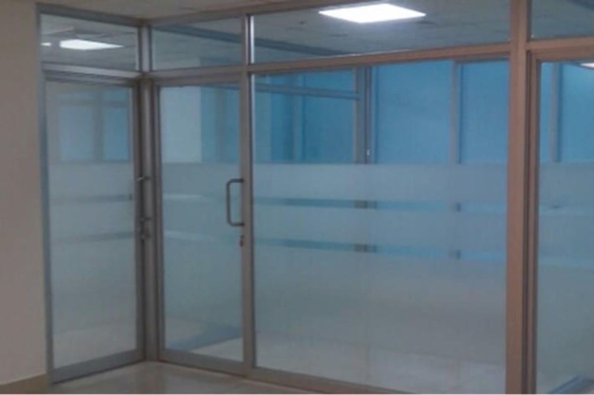 Meeting room with clear glass walls and chrome handles inside PH BICSA Financial Center Panama City