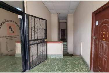 Back view of apartment building section with balconies and commercial units Colón Panama