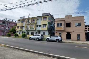 Panoramic street view of commercial and residential buildings with balconies Colón Panama