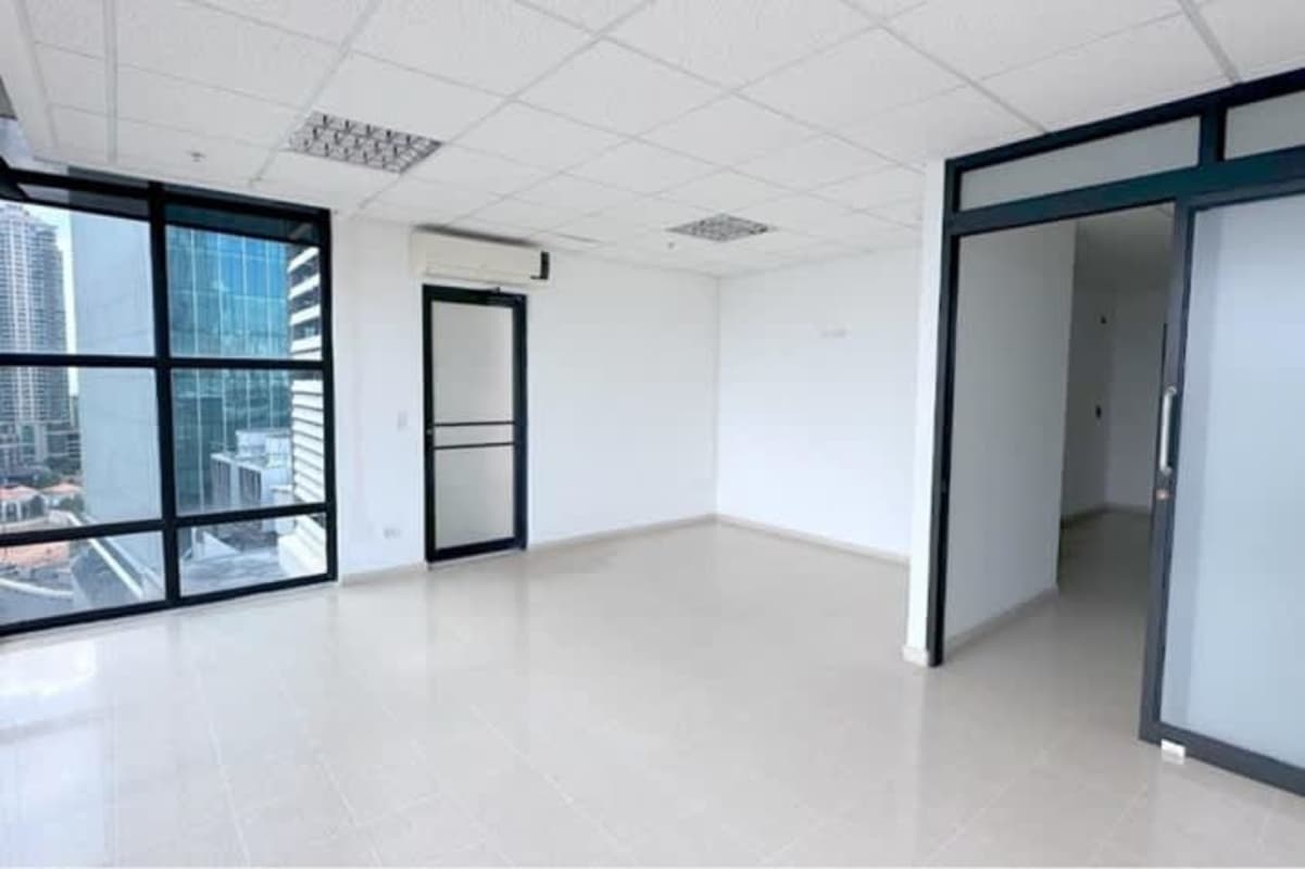 Empty office interior with large panoramic windows showing city skyline and ocean in PH The Point Panama City