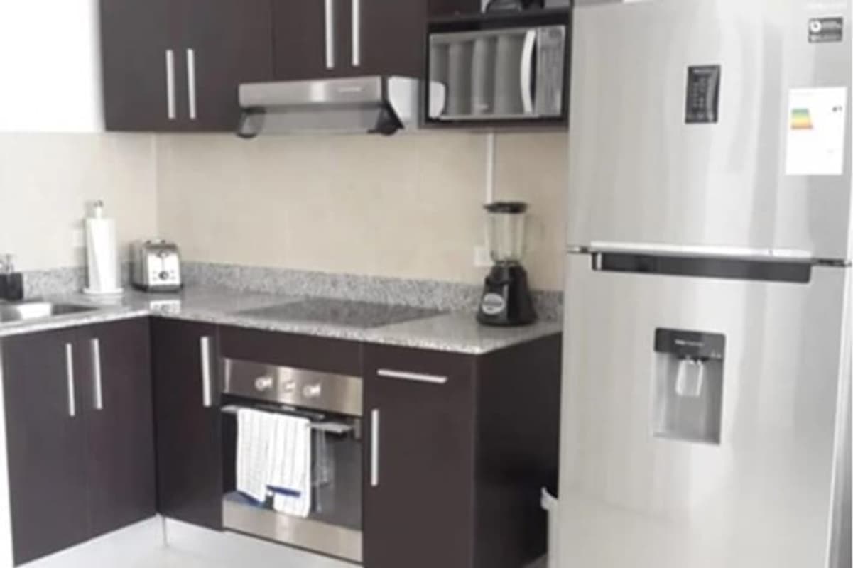 Modern kitchen with granite countertop, appliances and window view in PH Bay View Avenida Balboa