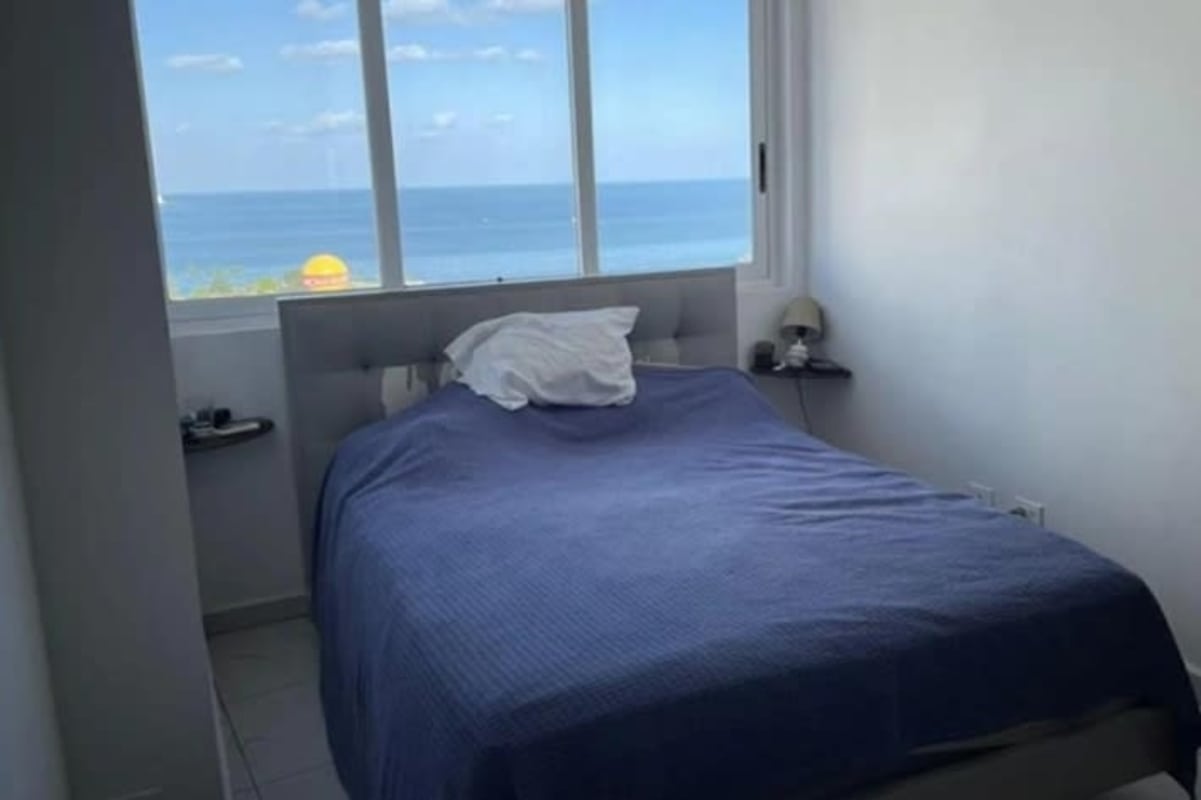 Bedroom with blue accents, minimal furniture and bay window view at PH Bay View Avenida Balboa