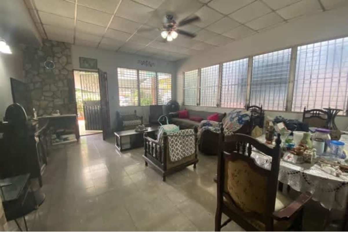 Open plan living and dining area with ceiling fan and large windows in Rio Abajo Panama house
