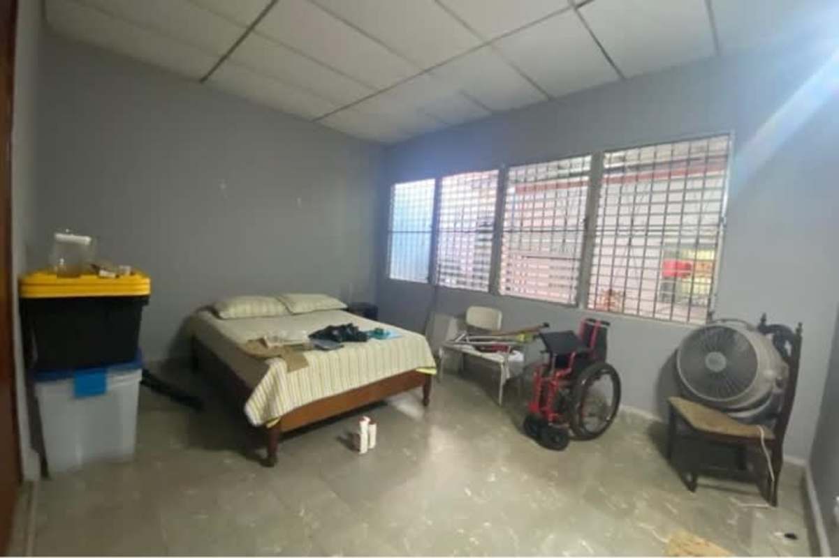 Simple bedroom with security window bars and tiled ceiling at Rio Abajo Panama house