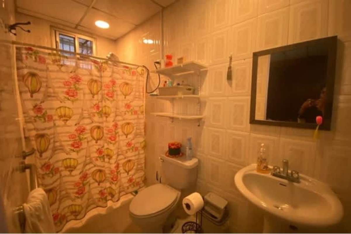 Traditional bathroom with mirror shelves, pedestal sink in Rio Abajo Panama house