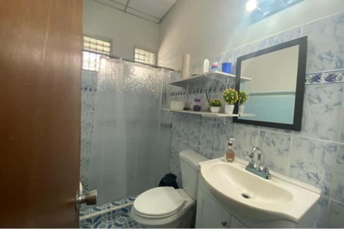 Full bathroom with blue tile, shelf, frosted curtain at Panama house for sale in Rio Abajo