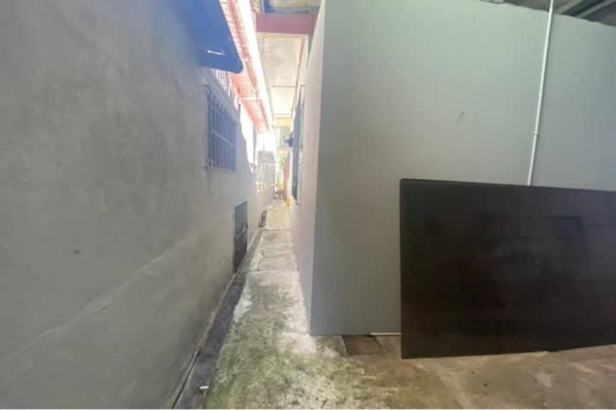 Bathroom with blue white tiles, sink, mirror and shower curtain in Rio Abajo Panama house