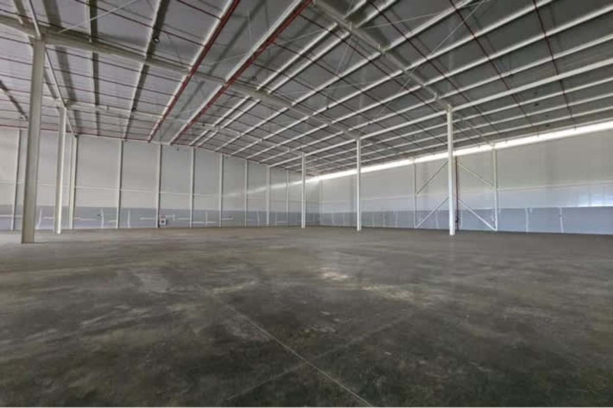 Empty industrial warehouse interior showing beams, lighting, concrete floors in Panapark Free Zone Tocumen Panama
