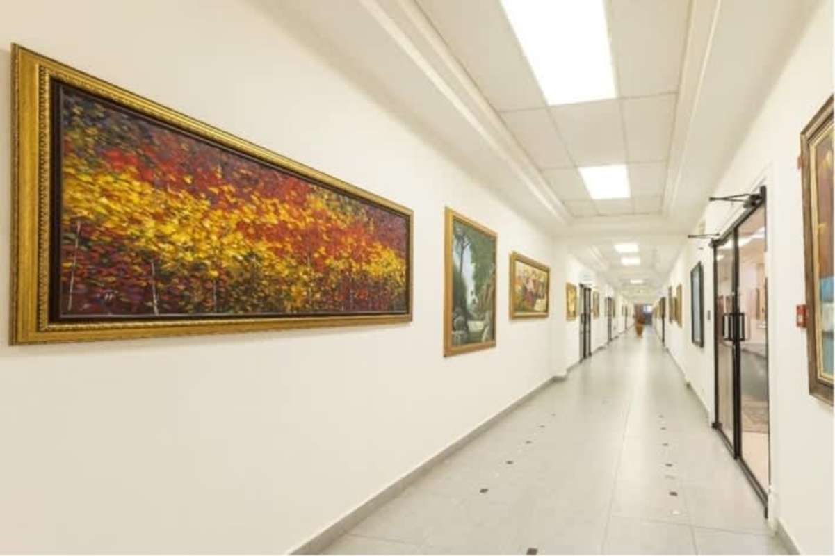 Hallway with recessed lights framed paintings white walls office tower Vista Hermosa Panama