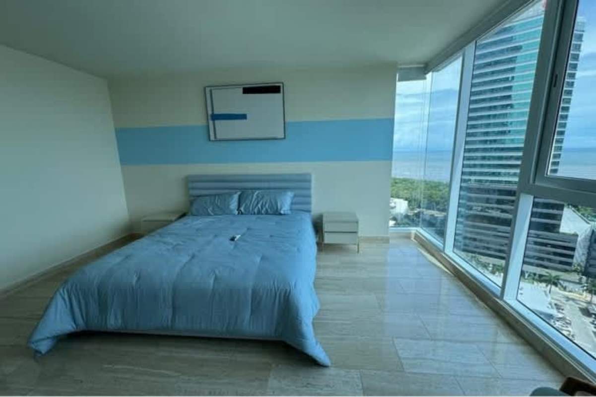 Modern bedroom light blue white decor floor to ceiling window ocean skyline PH Mirador Costa del Este Panama