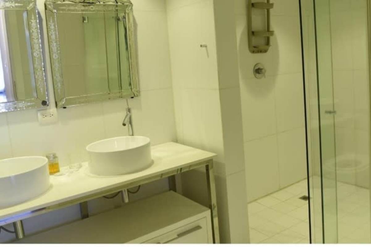 Elegant bathroom with double sinks large mirror glass shower in Yoo Panama Arts Tower