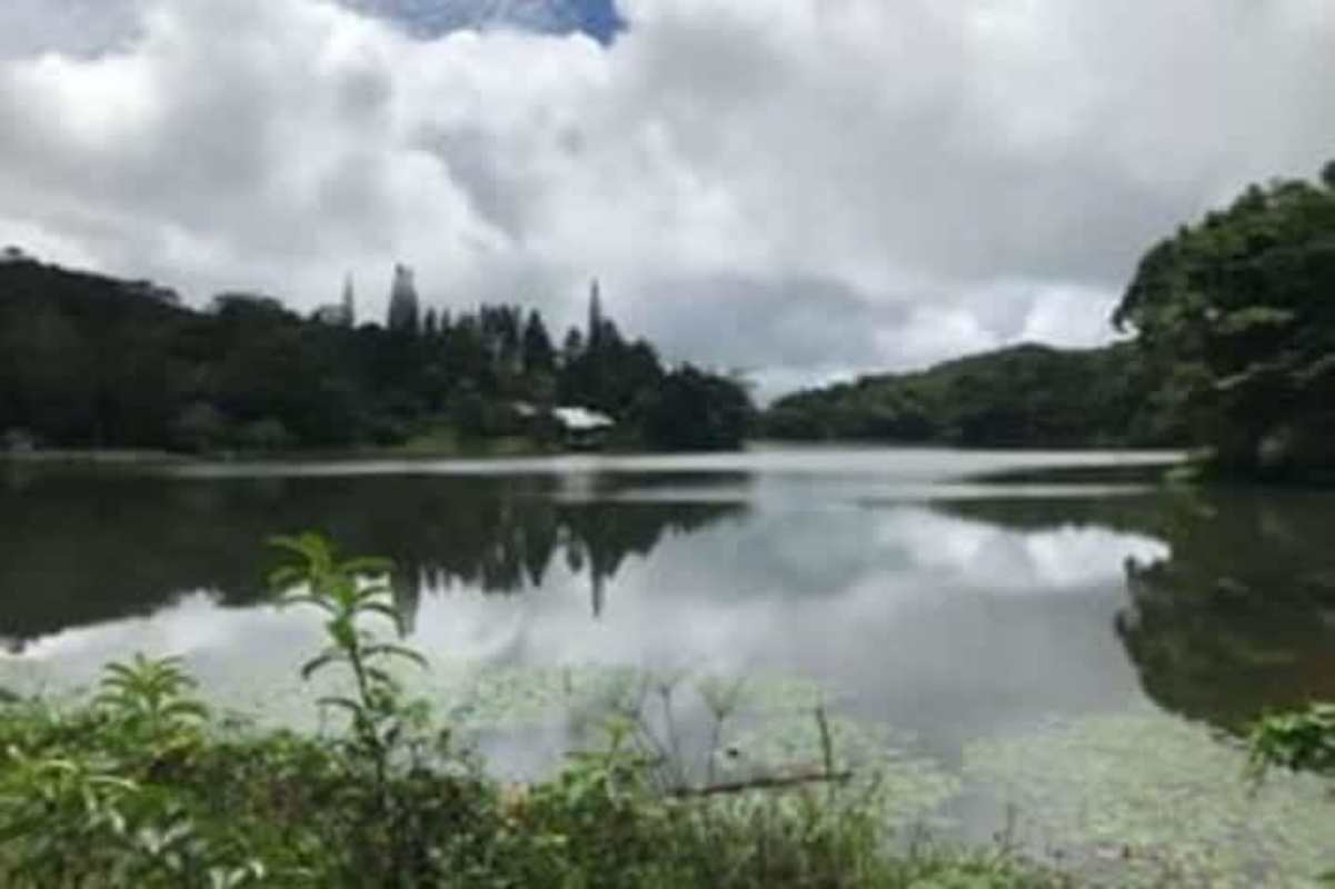 Calm blue lake reflecting sky surrounded by lush greenery in Cerro Azul Panama land for sale