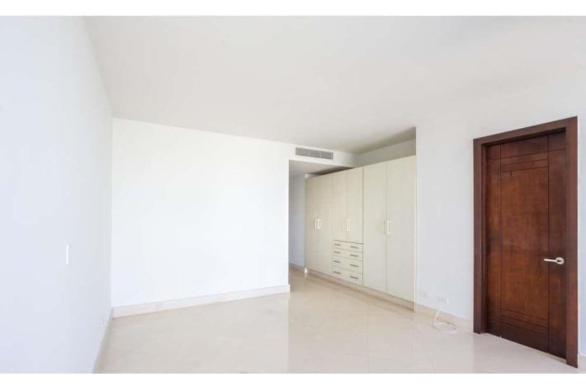 Modern bright bedroom with panoramic windows ocean city views in The Point Panama