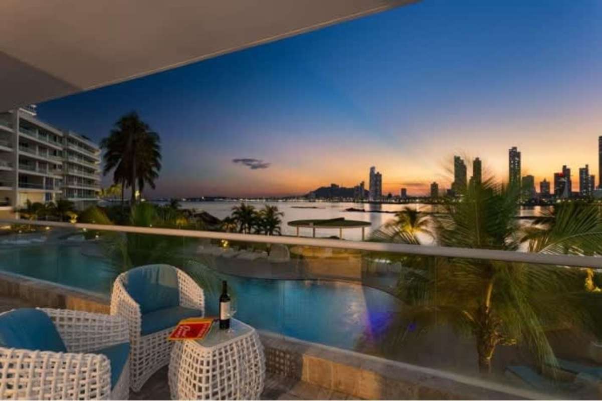 Infinity swimming pool with palm trees and skyline view at PH Miradores Punta Paitilla