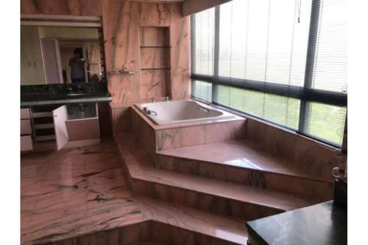 Penthouse marble bathroom with elevated Jacuzzi tub and panoramic windows in Panama City