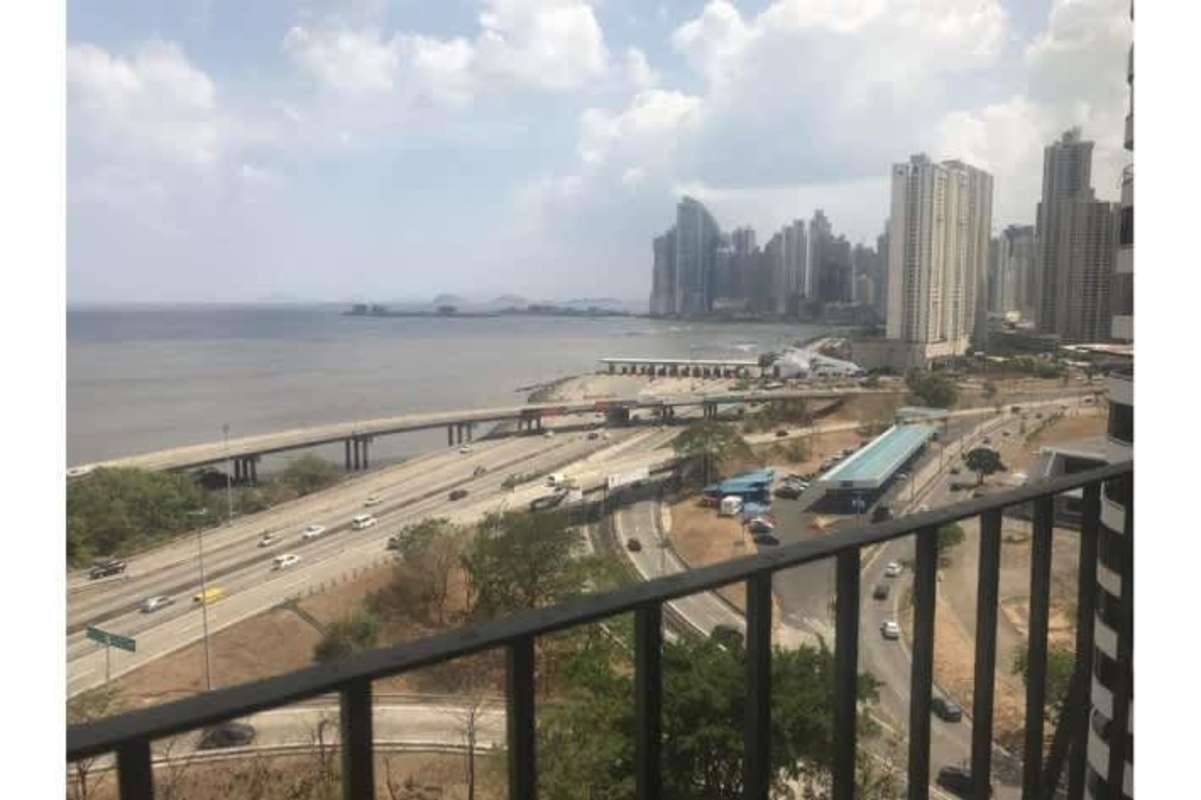View from penthouse balcony featuring coastal highway, ocean, and skyline Panama City
