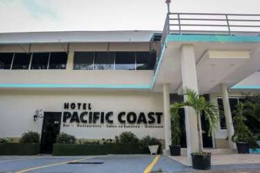Outdoor swimming pool with blue water, umbrellas, palm trees and garden at Pacific Coast Hotel Veracruz Panama