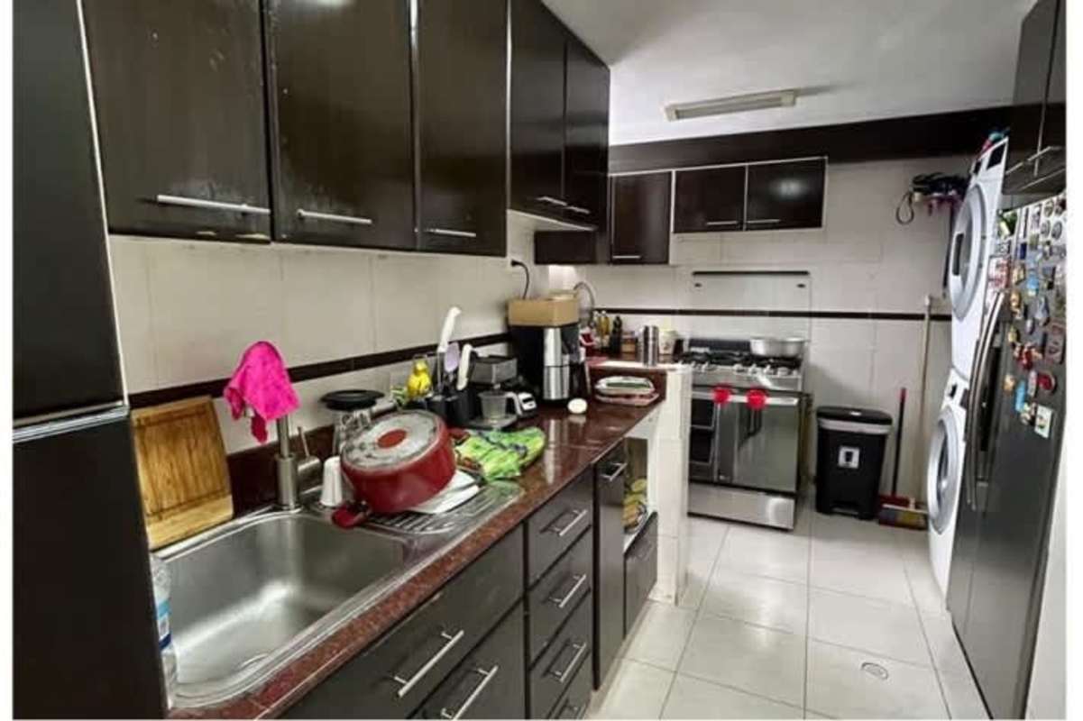 Modern kitchen with granite counters, wood cabinets and laundry space in PH Altos del Condado Panama