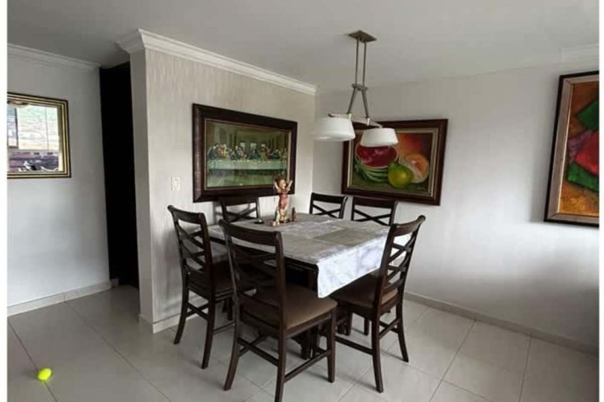 Spacious dining room area with wood table, chairs and decorative art in Condado del Rey Panama