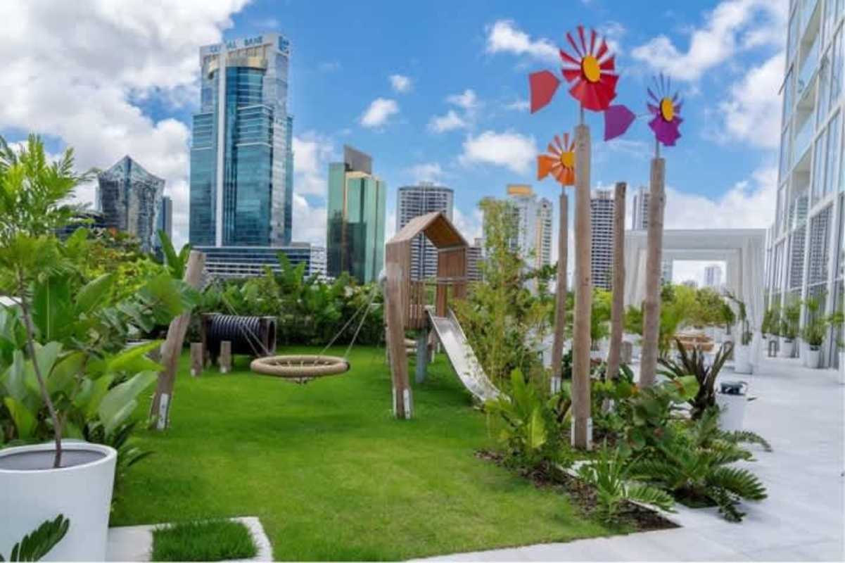 Rooftop garden and kids play zone featuring slides and swings at Empire Residences Panama City