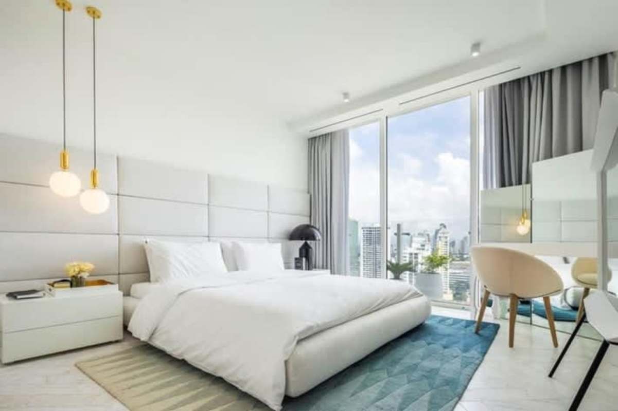 Elegant master bedroom with floor-to-ceiling windows and skyline view at Empire Residences Obarrio Panama