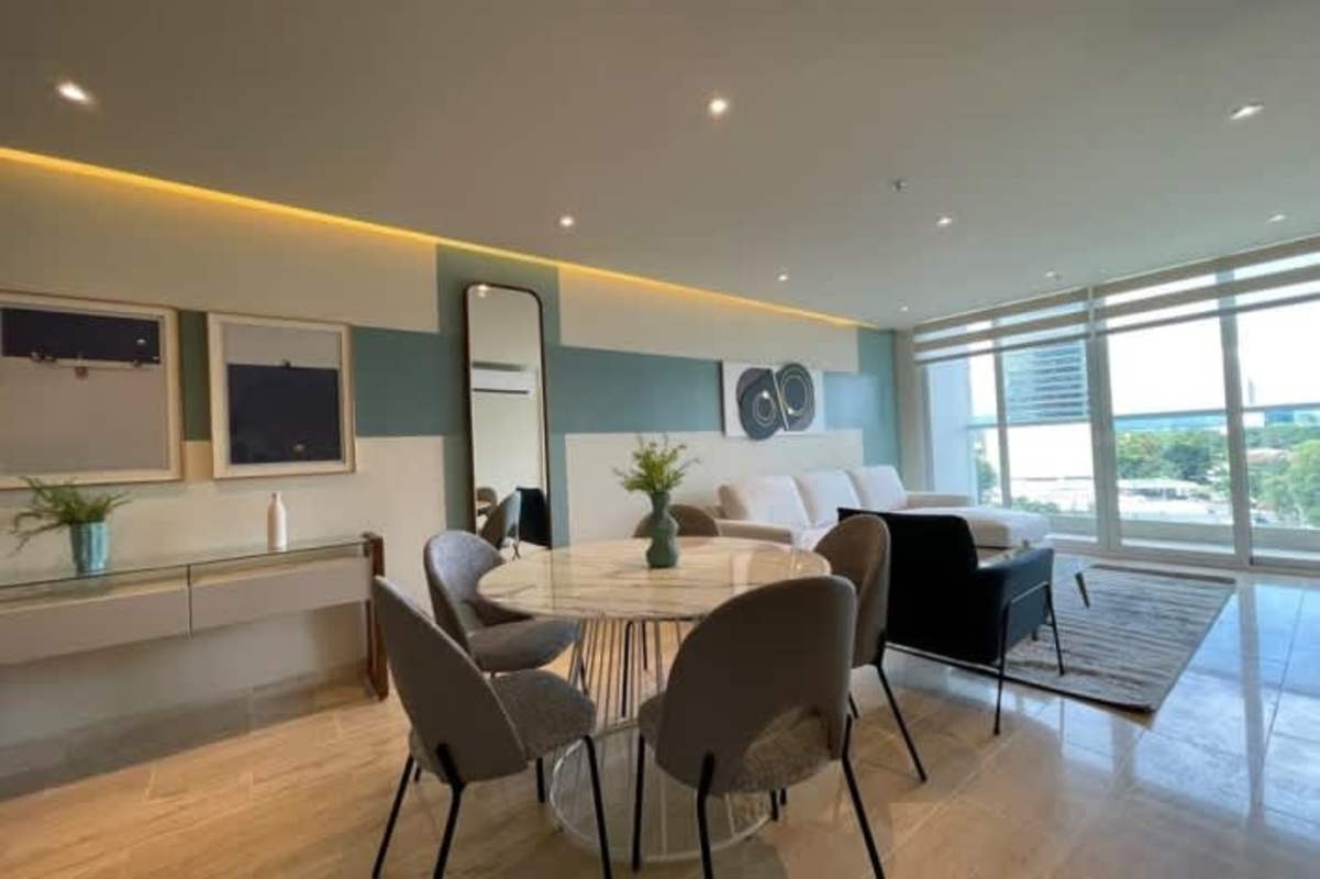 Open-plan dining area with large windows and glass balcony access at PH Costa View Costa del Este Panama