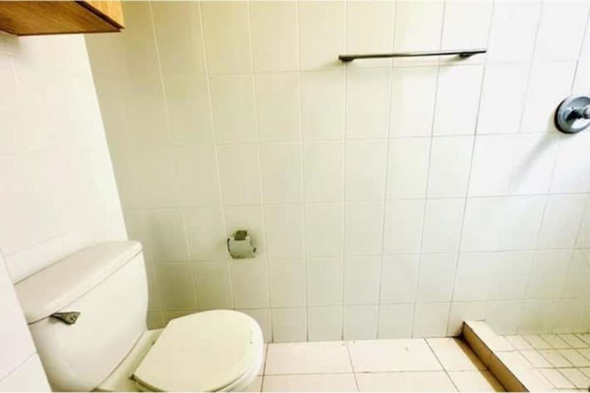 Outdoor swimming pool with lounge chairs and palm trees at San Francisco Bay condo Panama