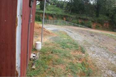 Gravel lot bordered by fencing and embankment grass Puerto Pilón Colón