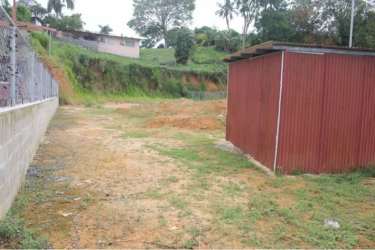 Open dirt lot with metal shed and chain-link fence in Puerto Pilón Colón Panama