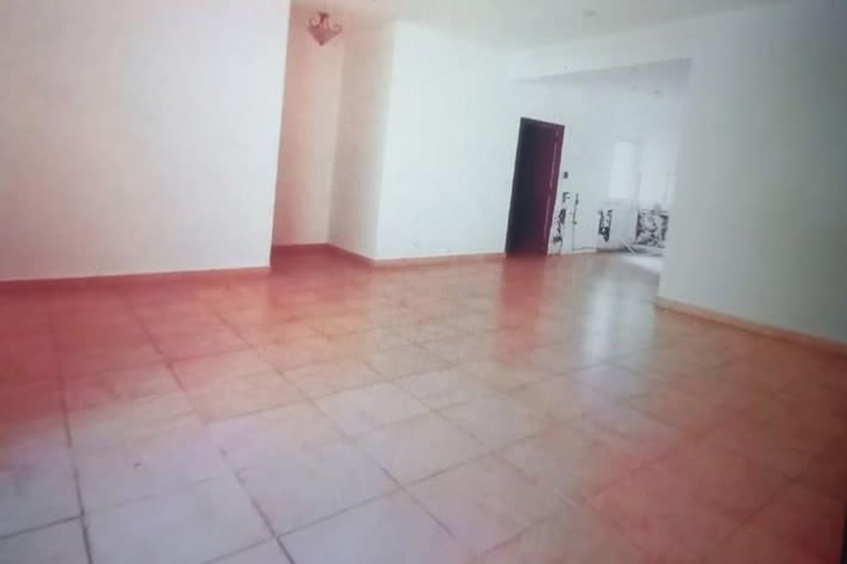 Spacious minimalist living room with tile flooring and access to kitchen PH Amador Hills Panama