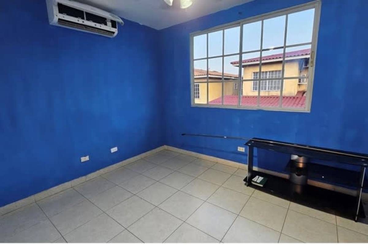 Two-story duplex with orange facade, carport, garden, tile roof in PH Dorado Lakes Condado del Rey Panama