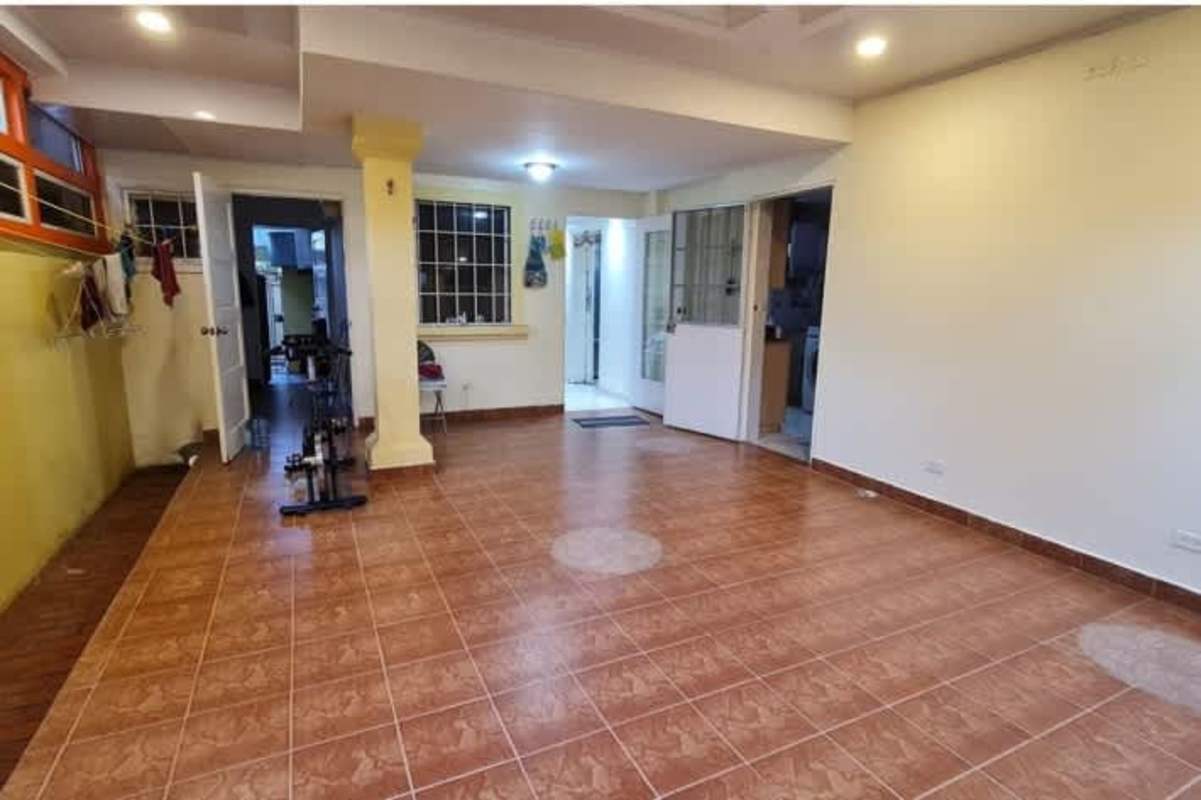 Spacious bedroom with pink walls, AC, and large windows in Dorado Lakes duplex Panama City