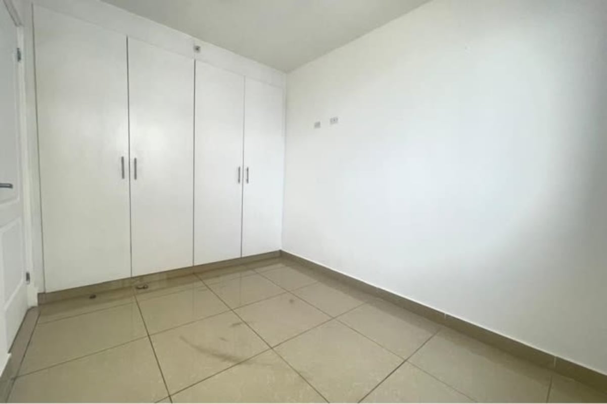 Cozy bedroom with built-in closet and large window providing city view in PH Vía Romana Panama City