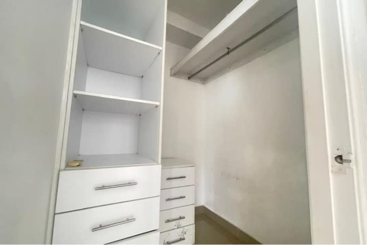Spacious white walk-in closet with shelving and drawers PH Vía Romana Panama City