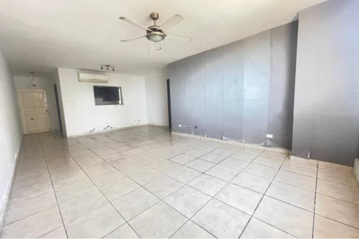 Living room with tile floor, AC, ceiling fan, gray accent wall PH San Francisco Tower