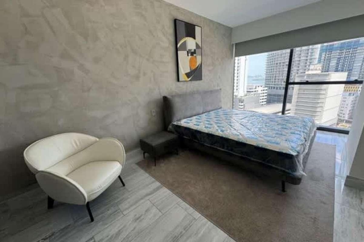 Spacious master bedroom with large window offering views of Panama Bay Yoo Panama