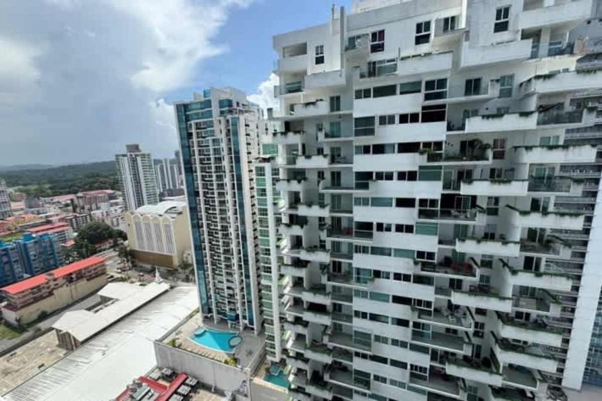 View of PH BICSA skyscraper with outdoor pools, balconies, and ocean backdrop in Panama City