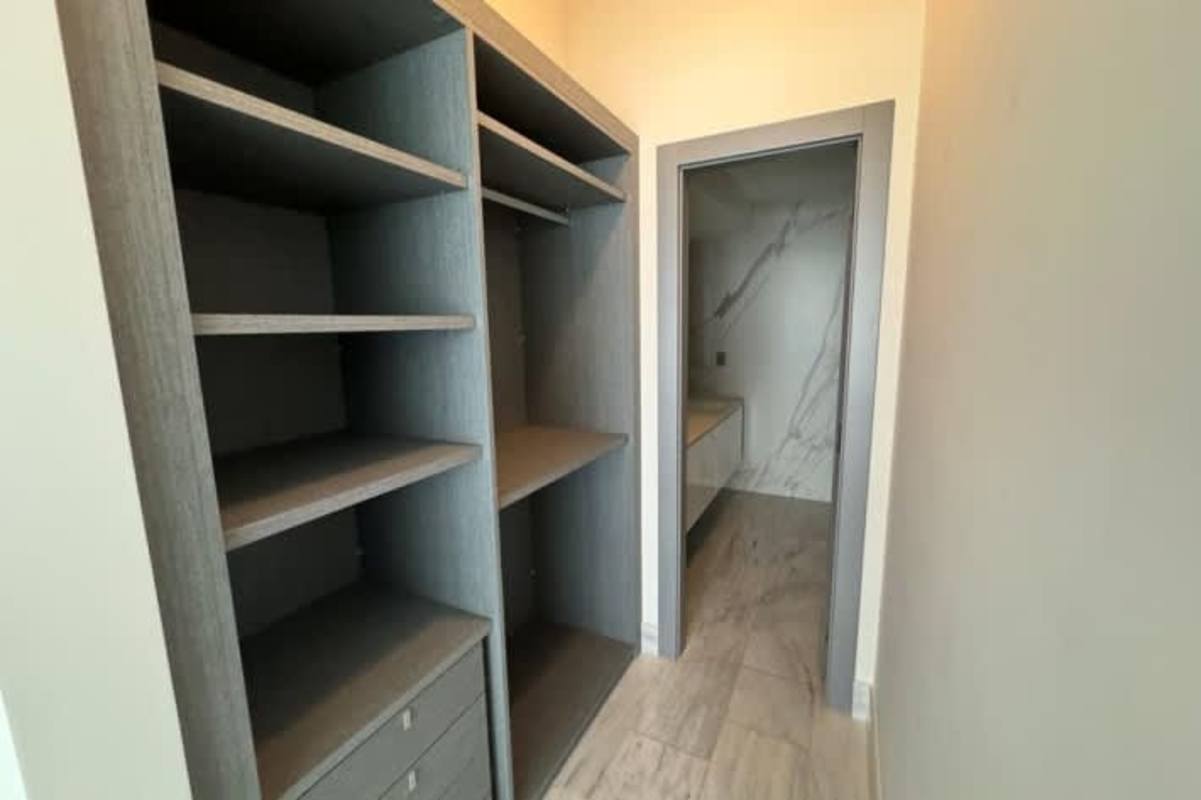 Spacious walk-in closet leading to marble accented bathroom in luxury apartment PH BICSA Panama City
