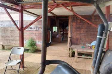 Wooden porch with exposed beams, bench and metal roof in rural farm property Panama
