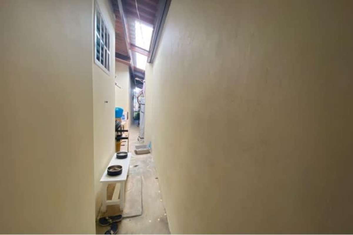 Outdoor narrow corridor with skylights of family house in Brisas del Golf Panama