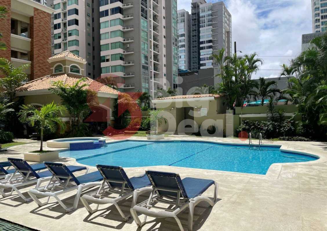 Outdoor swimming pool with lounge chairs and city high-rise view PH Green Bay Panama City