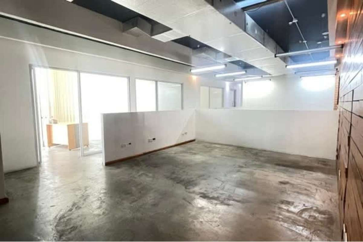 Industrial-style open office with exposed ceiling ductwork, concrete floor in PH BICSA Panama City