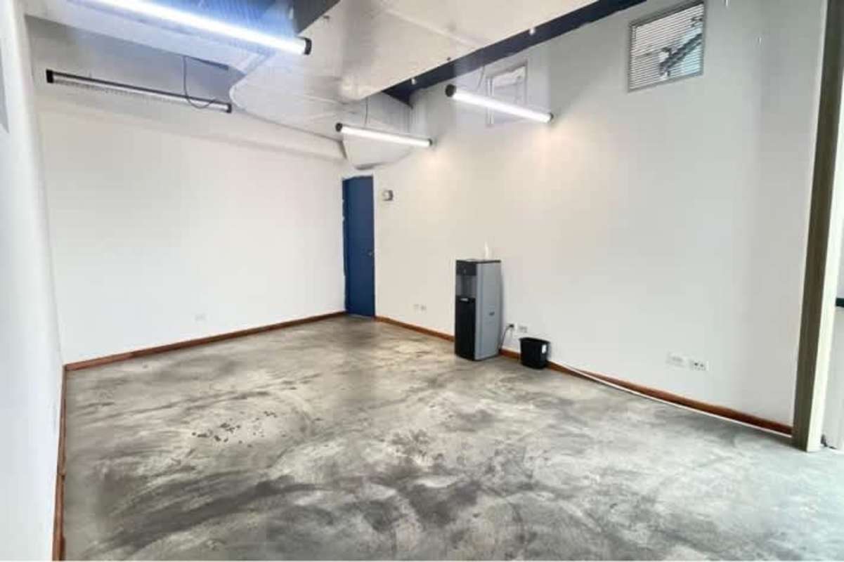 Bright modern office space with exposed ceiling, large windows and white walls at PH BICSA Panama City