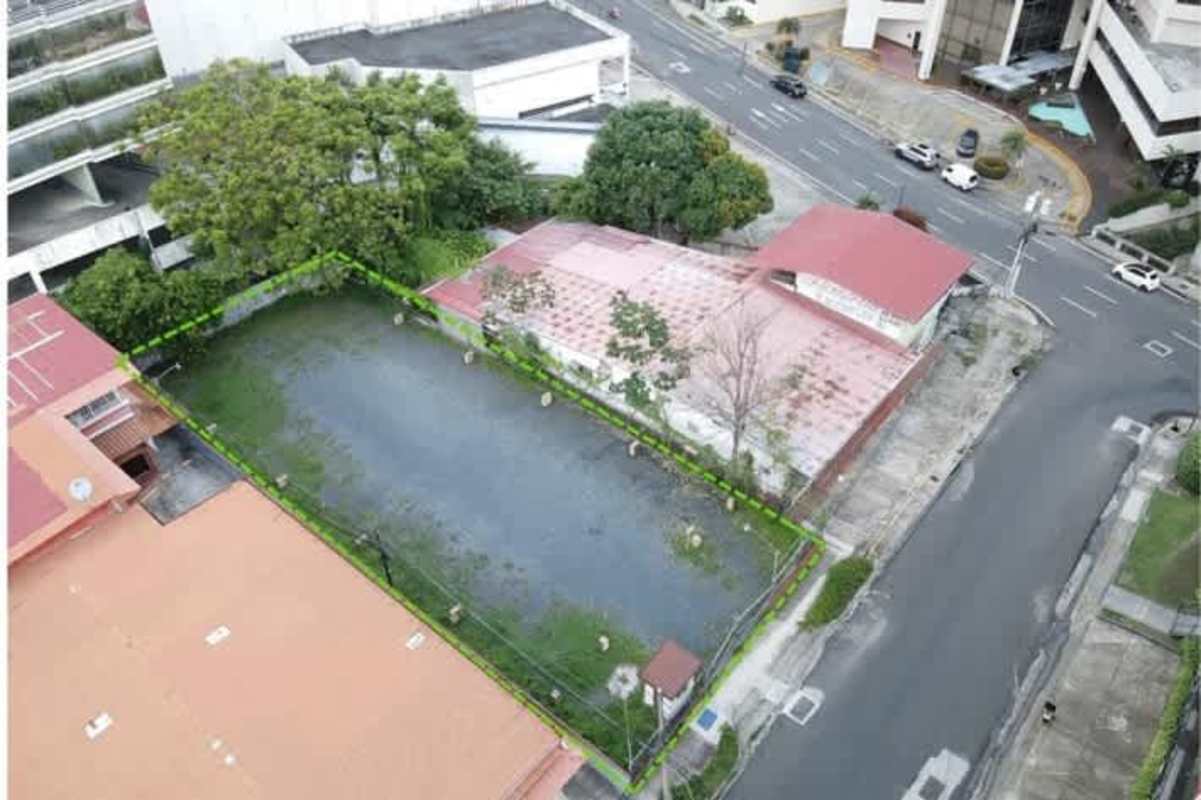 Fenced vacant city lot corner in Banking District Obarrio with adjacent buildings and traffic access