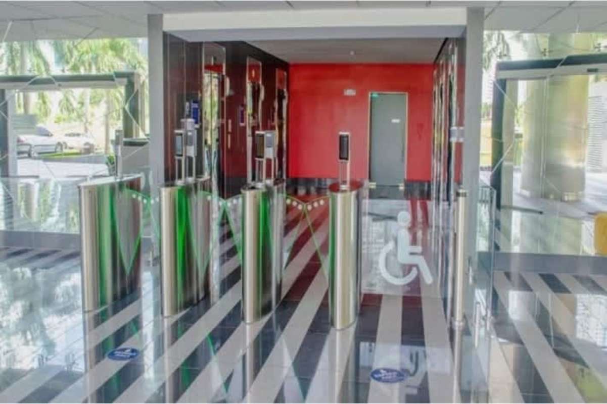 Modern lobby entrance security turnstiles with glass barriers Times Square Center Costa del Este