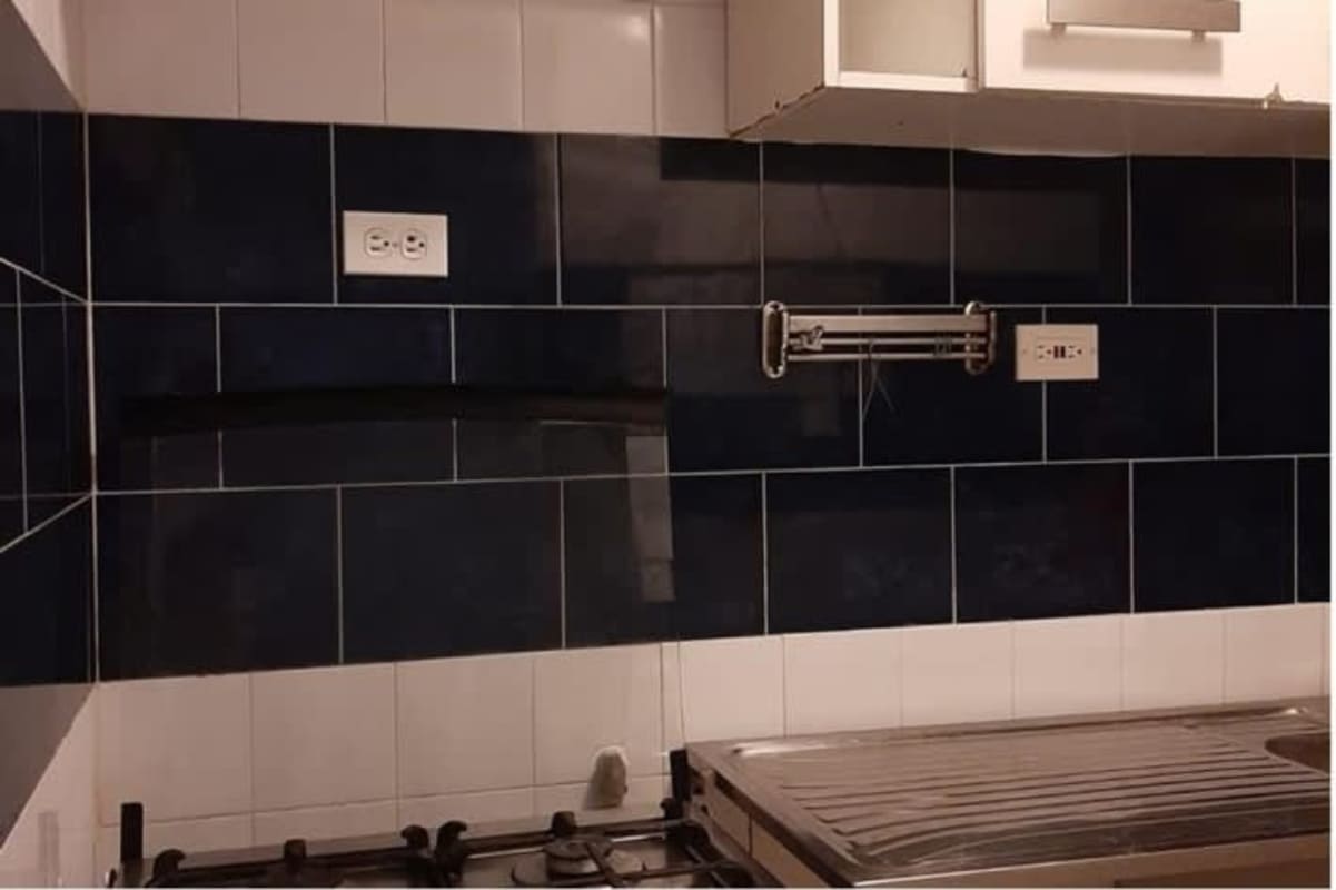 Kitchen with blue white tiles, stainless sink, gas stove in Juan Díaz apartment Panama
