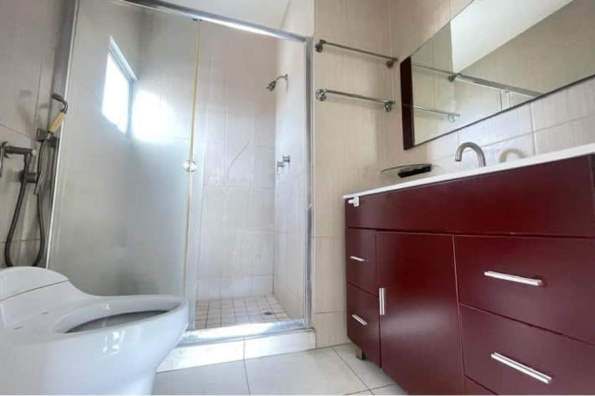 Bathroom with glass shower enclosure and modern fixtures in Betania apartment