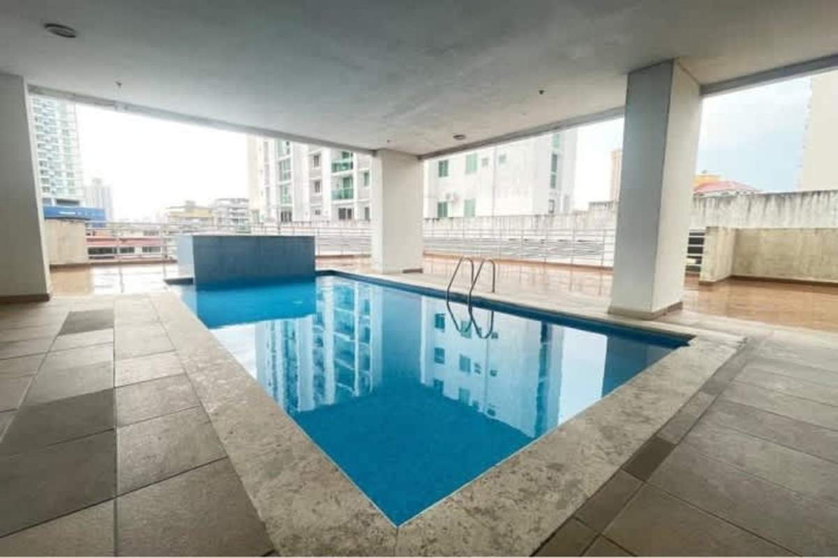 Covered outdoor swimming pool with sun loungers city view PH El Cangrejo Panama